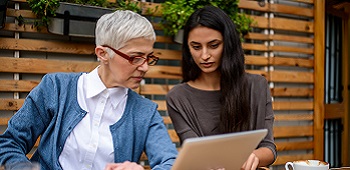 Two woman sitting together reading