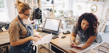 Two women discussing business in a shop.