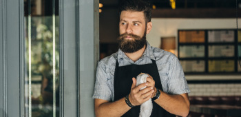 A small business owner standing in the doorway of his premises