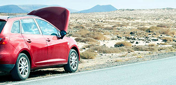 Car broken down in a rural setting with the bonnet raised