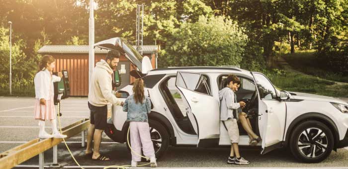 Family getting into an electric vehicle about to embark on their road trip