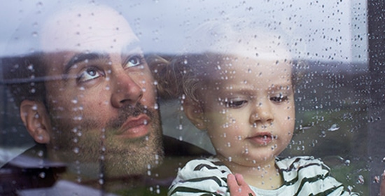 Dad and daughter looking out of a rainy window Dad and daughter looking out of a rainy window