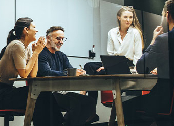 Workers in discussion around a desk Workers in discussion around a desk