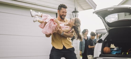 A father carrying his daughter to the car