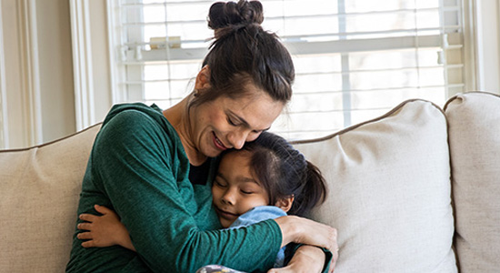 A woman hugging a young girl