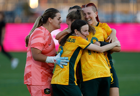 The Matildas in a celebratory group hug