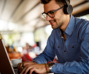 man typing with a headset on